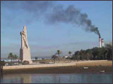 Imagen de la Estatua de Cristóbal Colón de Huelva, con el Polo Químico al fondo